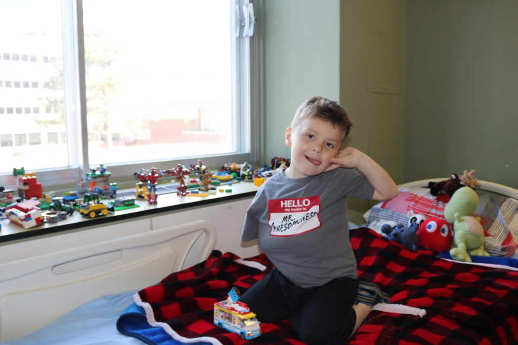 Photo - Nathan, dans sa chambre d'hôpital, entouré de nombreux ensembles de blocs Lego qu'il a assemblé pendant son long séjour.