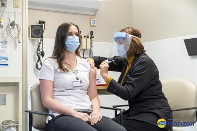 Nicolette Noel, une infirmière immatriculée de l'Unité de soins intensifs de l'Hôpital régional de Miramichi du Réseau de santé Horizon, est la première personne et la première travailleuse de la santé au Nouveau-Brunswick à recevoir le vaccin contre la COVID-19, le samedi 19 décembre. C'est la mère de Nicolette, Nanette Noel, une infirmière de la Santé publique, qui lui a administré le vaccin.