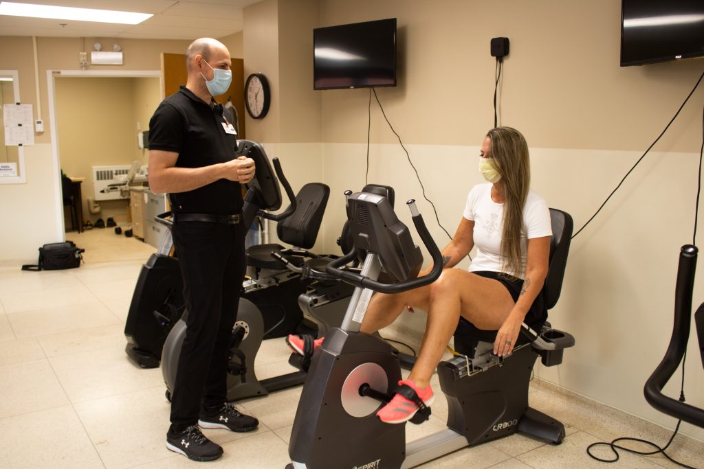 Carla Chadwick, qui a récemment fait remplacer son autre genou, s'échauffe dans le gymnase de physiothérapeute du genou sous les conseils du physiothérapeute Justin Saulnier.